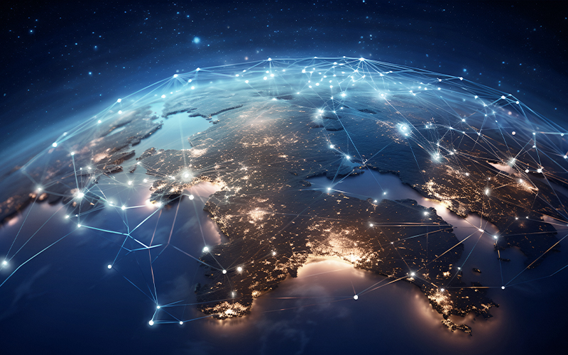 An image of the globe seen from outer space, illuminated by network lines and nodes that depict concepts of data flow, technology, and global communication under a night sky scattered with stars.