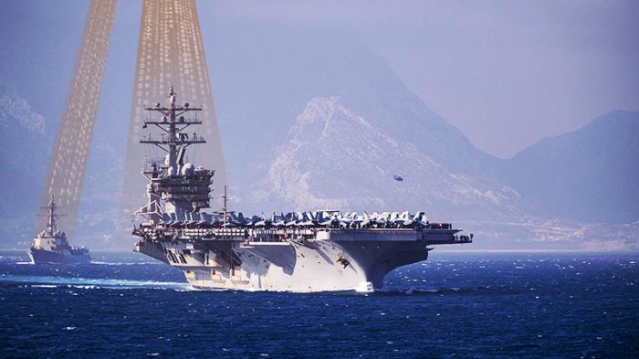 A picture of a ship at sea with an antenna receiving a signal from a satellite.